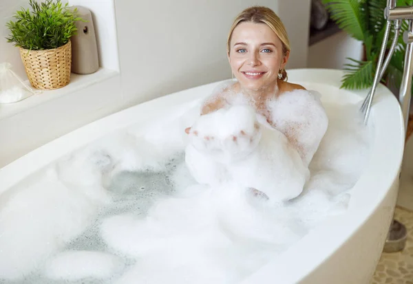 Retrato de jovem loira bonita mulher sorrindo e gostando de bolhas na banheira. — Fotografia de Stock