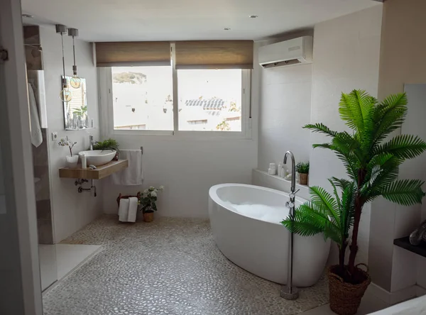 Intérieur d'une belle salle de bain confortable avec baignoire bouillonnante chaude, fenêtre et miroir. Chambre vide. — Photo