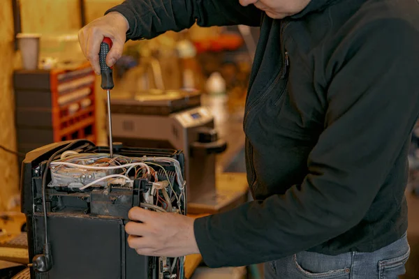 Mains électriciennes réparant la machine à café dans l'atelier — Photo