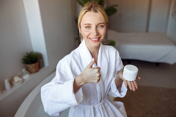 Joven Mujer Caucásica Alegre Sonriendo Sosteniendo Crema Dando Pulgar Hacia —  Fotos de Stock