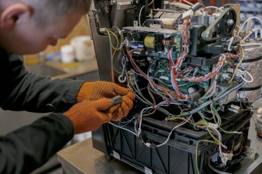 İçerideki masada kahve makinesini tamir eden tornavidalı bir tamirci. Yüksek kalite fotoğraf