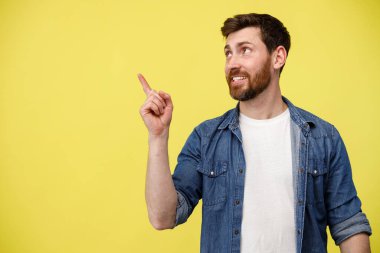 Gülümseyen adam parmağını kaldırıp boş uzayı işaret ederek yana bakıyor. Stüdyo çekimi