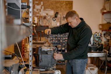 İçerideki masada kahve makinesini tamir eden tornavidalı bir tamirci. Yüksek kalite fotoğraf