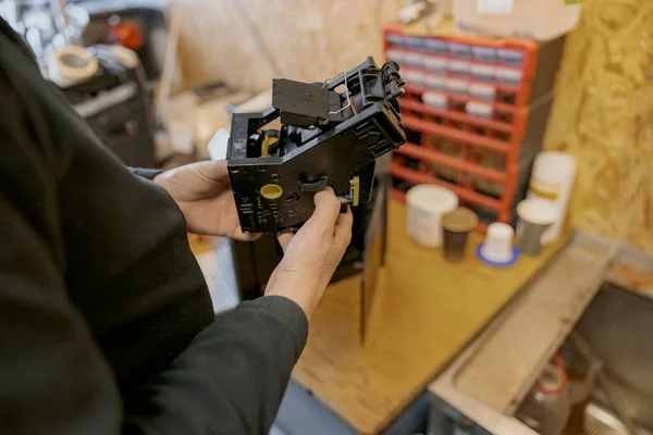 Close up of professional worker inspecting detail of coffee machine in workshop. High quality photo