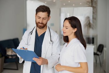 Hasta teşhisini tartışan iki doktor klinikte duruyor. Yüksek kalite fotoğraf