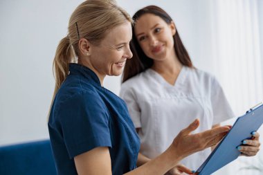 Klinikte resepsiyonda duran doktor ve hemşire iş sorunlarını çözüyor. Yüksek kalite fotoğraf