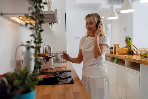 Kulaklıklı Mutlu Bir Kadın Krep Pişiriyor Müzik Dinliyor Kadın Yemek — Stok fotoğraf