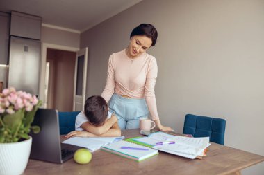 Annesi ödevlerini kontrol ederken küçük çocuğun uyumasından ya da masada ağlamasından yoruldum. Tembel öğrenci. Çevrimiçi.