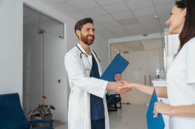 Klinikte resepsiyonun yanında el sıkışan iki doktor. Yüksek kalite fotoğraf