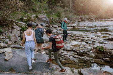 Rock Dağları Vadisi 'nde nehirle yürüyen yürüyüşçü çiftlerin arkası. Yürüyüş konsepti. Arka plan.