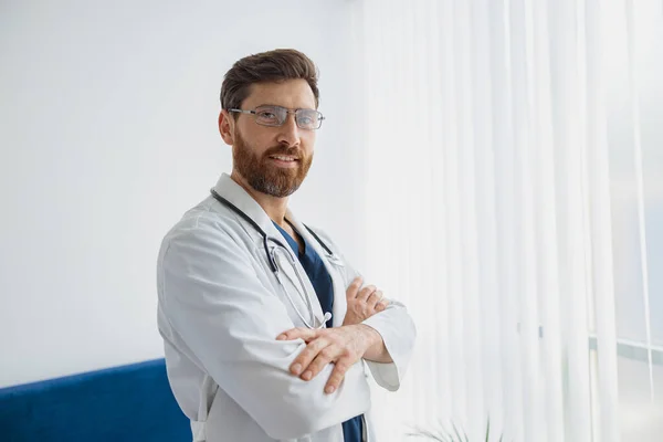 Portrait of doctor in glasses standing in medicine clinic and looking camera. High quality photo