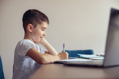 Diş teli takan, kitap yazan ve gülümseyen sevimli bir çocuk. Çevrim içi öğrenim.