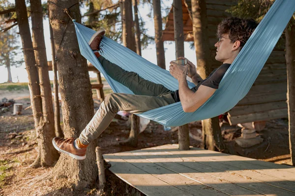 Junger Mann Beim Entspannungstag Waldhaus Morgens Kaffee Der Hängematte Holz — Stockfoto