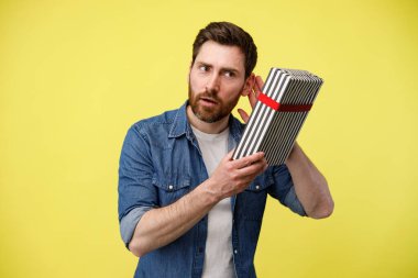 Hediye kutusundaki tıkırtıları dinleyen ilgili adamın portresi. Bil bakalım içeride ne var? Stüdyo çekimi