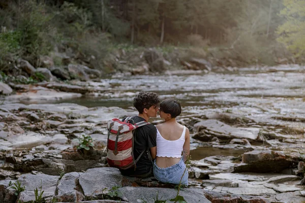 Kayalık Nehir Kıyısında Oturan Öpüşen Bir Çift Yürüyüşçünün Arka Görüntüsü — Stok fotoğraf