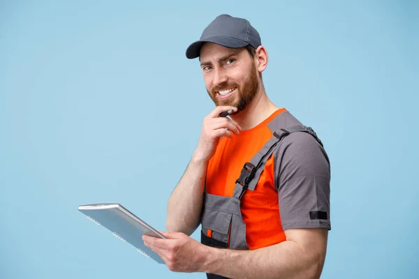 Pekerja Yang Tersenyum Berseragam Menyentuh Jenggotnya Sambil Memegang Tablet Latar — Stok Foto