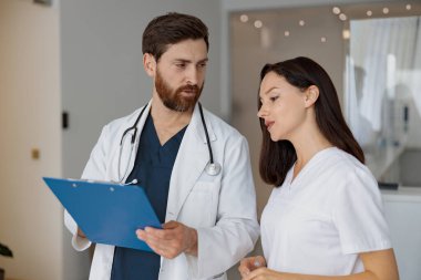 Klinikte resepsiyonda duran doktor ve hemşire iş sorunlarını çözüyor. Yüksek kalite fotoğraf