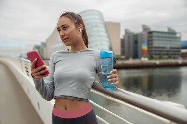 Dışarıda aktif fitness eğitiminden sonra dinlenirken cep telefonuyla sohbet etmeyi kapat.