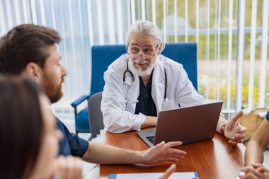 Hastanenin ofisindeki masada oturan bir grup doktor konuşuyor. Yüksek kalite fotoğraf