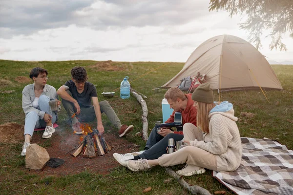 Company Friends Hikers Resting Fire Camp Site Talking Hot Drinks — Photo