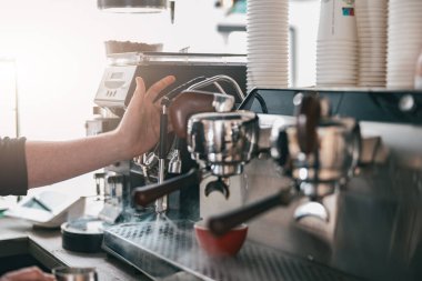 Kafedeki otomatik kahve makinesinde kahve espresso hazırlama görüntüsünü kapat. Bulanık arkaplan