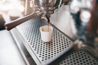 Kafedeki otomatik kahve makinesinde kahve espresso hazırlama görüntüsünü kapat. Bulanık arkaplan