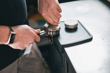 Barista 'nın elinde kahve tutacağı ve kahve tutacağı var. Müşteriye kahve yapmak için.