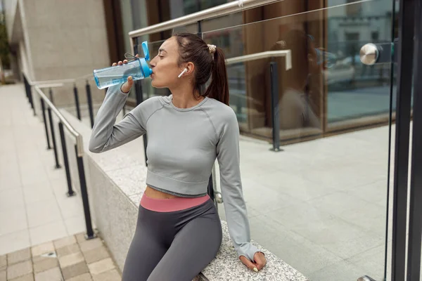 Fitness Woman Drinking Water Bottle Workout Sitting Grey Wall High — Foto de Stock