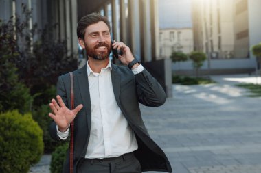 Satisfied Businessman going home after long working day and talking phone. Blurred background