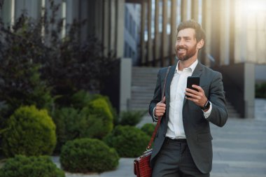 Satisfied Businessman going home after long working day and looking at side. Blurred background