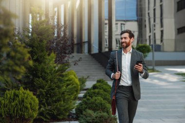Satisfied Businessman going home after long working day and looking at side. Blurred background