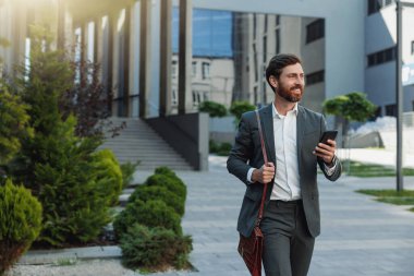 Satisfied Businessman going home after long working day and looking at side. Blurred background