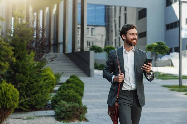 Satisfied Businessman going home after long working day and looking at side. Blurred background