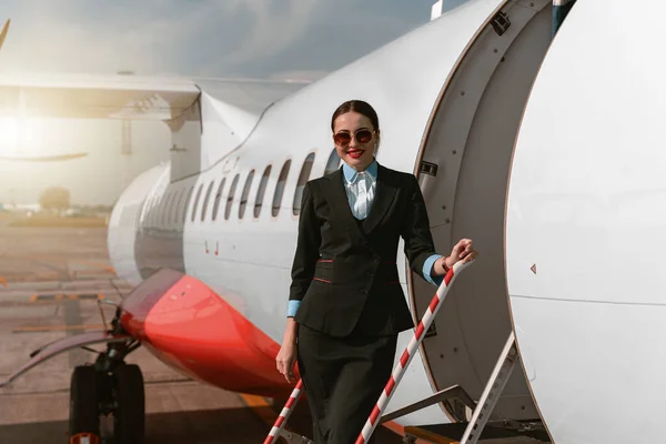 Woman Flight Attendant Sunglasses Standing Airplane Stairs Airport Blurred Background — Stock fotografie