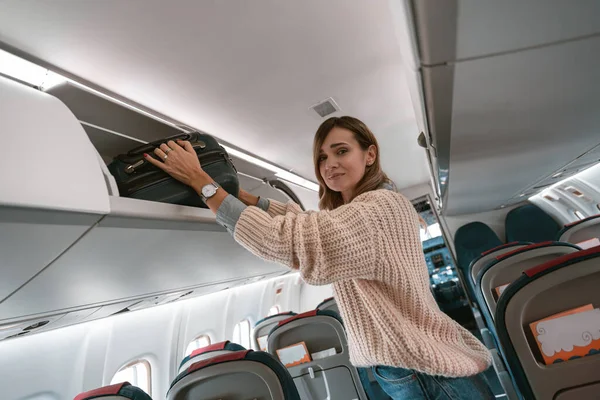 Woman Traveler Putting Luggage Overhead Locker Airplane Boarding High Quality — Foto de Stock