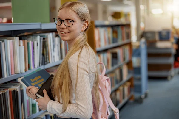 Female Student Glasses Chooses Book While Standing University Library Blurred — Stockfoto