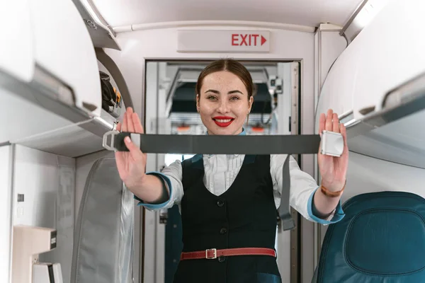 Flight attendant demonstrates flight safety instruction by using seat belt . High quality photo