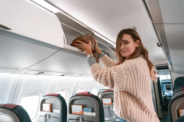 Woman Traveler Putting Luggage Overhead Locker Airplane Boarding High Quality — Foto de Stock