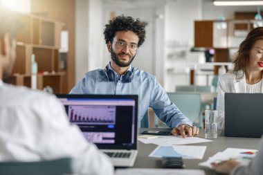 Businesspeople working together in bright office, sitting at desk. High quality photo