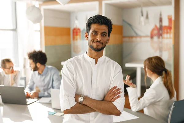 Smiling Indian Businessman Standing Modern Office Colleagues Background — Stockfoto