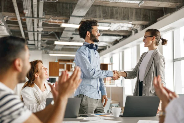 Female boss leader shaking hand of new team member recruiting him for job on staff briefin