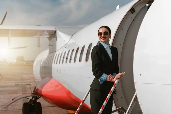 Woman Flight Attendant Sunglasses Standing Airplane Stairs Airport Blurred Background — Stok Foto