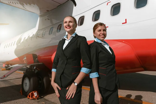 Cheerful Flight Attendants Standing Back Back Airport Blurred Background —  Fotos de Stock