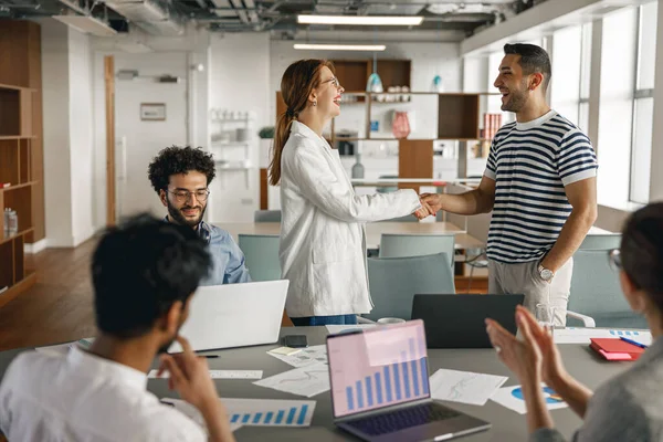 Female boss leader shaking hand of new team member recruiting him for job on staff briefin