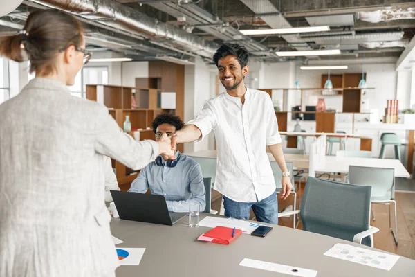 Female boss leader shaking hand of new team member recruiting him for job on staff briefin