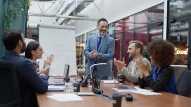 Mature coach or speaker make flip chart presentation to diverse businesspeople at meeting