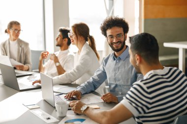 Coworkers cooperating and working together at office meeting, teamwork concept. Blurred background