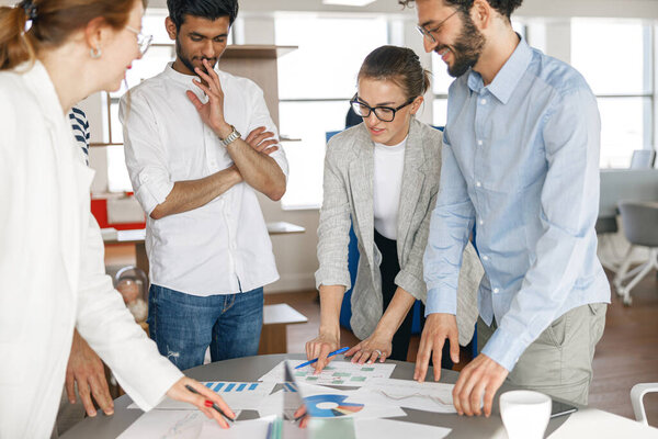 Coworkers cooperating and working together at office meeting, teamwork concept. Blurred background