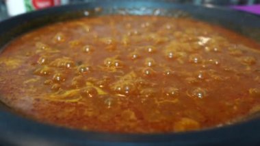 Paella pişirirken kaynayan baloncukları kapat.