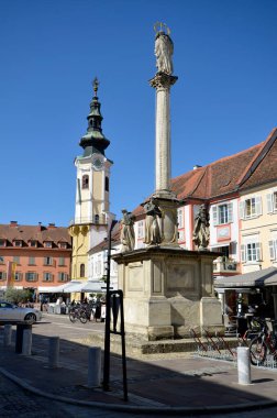 Bad Radkersburg, Avusturya - 24 Eylül 2021: Kasaba meydanında kafe, restoran, market tezgahları, Marian sütun ve belediye binası bulunan kimliği belirsiz kişiler, Slovenya sınırı, yer ve bölge bisikletli için tercih edilen bir yer